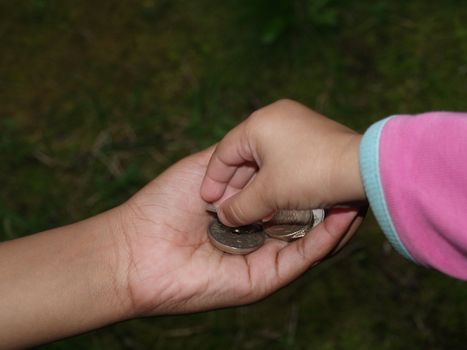 childrens hand sharing norwegian coins