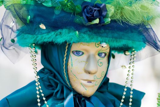 Carnival in venice with model dressed in various costumes and masks - green lady