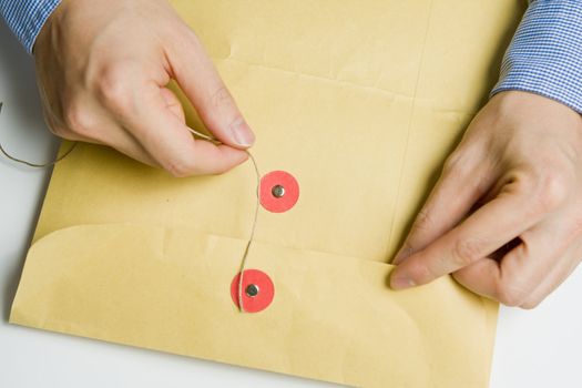 Person opening a confidential official document in an envelope