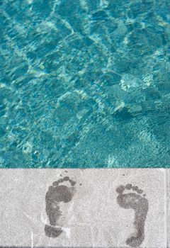 Footprints with turqoise blue swimming pool at vacation resort