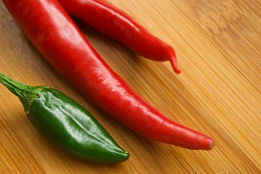 Green and red pepper over wooden background