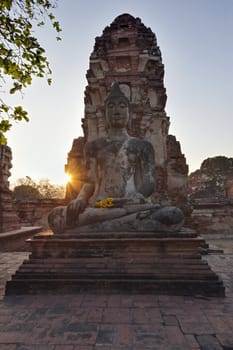 THAILAND, Ayutthaya, an ancient Buddha statue at sunset