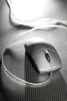 Silver computer wired mouse close up over metal steel background