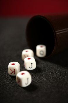 Poker game dices over black table, low key image