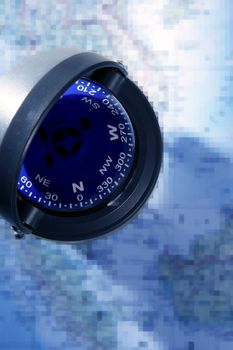 Nautical compass over a blue chart map, travel metaphor