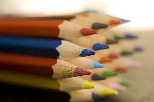 Close up of group of multi-colored coloring pencils isolated on blsck background.