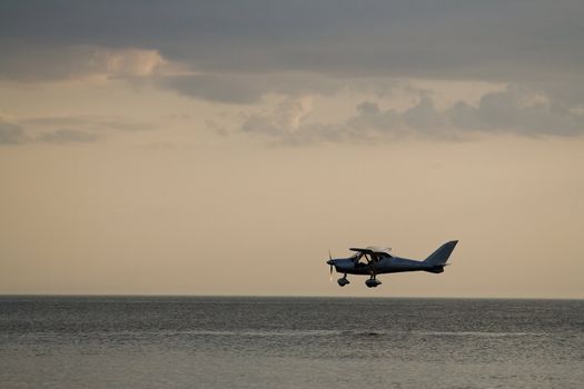 Low flying small private airplane over sea