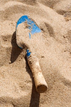 Forgoten blue sand spade in sandy beach