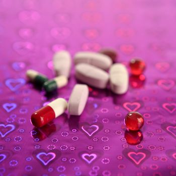 medical pills over holographic purple shiny background