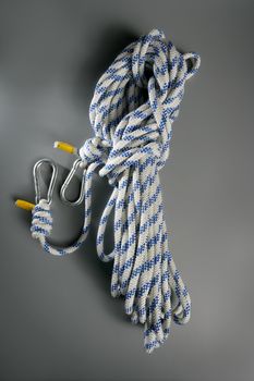 Sport rope with two climbing steel carabiner on edges. over gray