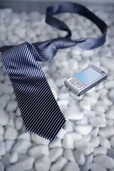 Businessman on a break, left his tie and phone on a modern white stones table