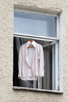 Men's shirts dried after washing in the open window of the house 