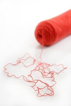 Red thread spool isolated over white studio background