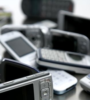 Assorted mixed mobile phones, old, new technology in cell telephones