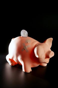 Saving money in crisis time, wounded piggy bank