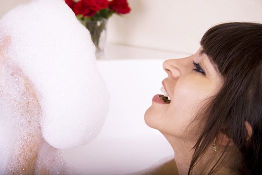 Woman in a jacuzzi playing with the foam