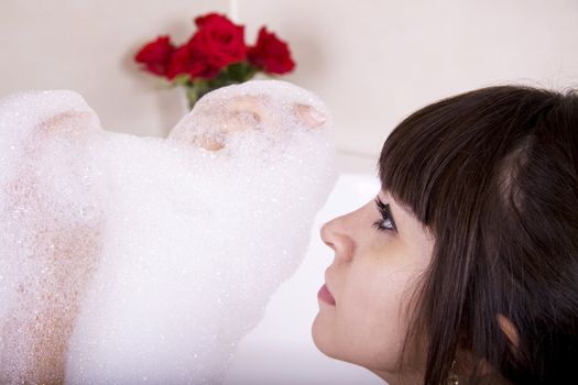 Woman in a jacuzzi playing with the foam