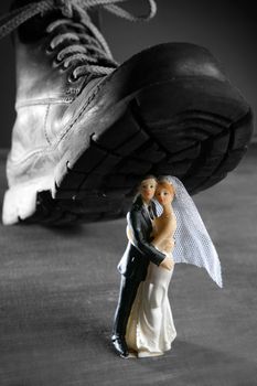 Tread a marriage couple figurine with a big old boot, divorce metaphor