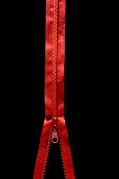 Red clothes zip isolated over black background