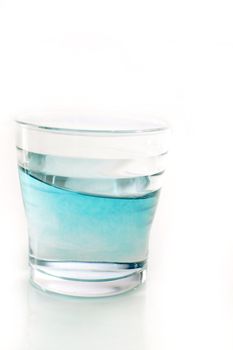 Glass of blue turquoise color moving water, isolated on white background