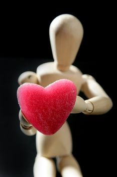 Wooden mannequin holding a red jelly candy heart shaped