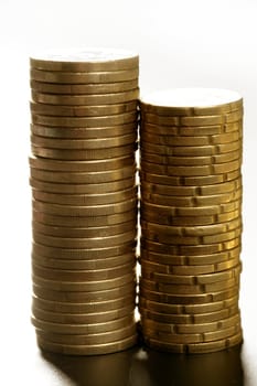 Euro coin columns, golden cash over white background at studio