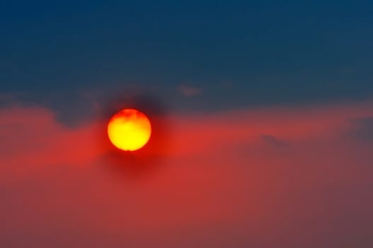 Setting sun with clouds colored red and bluish black