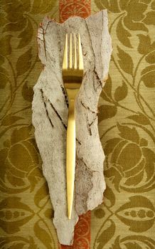 Golden fork over indian tablecloth