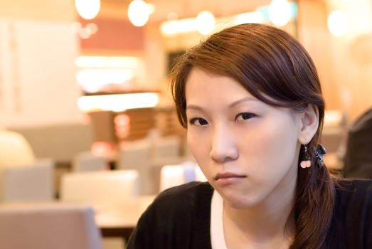Here is a eastern asian girl wait and angry in restaurant.