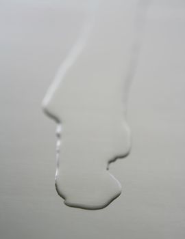 Liquid,transparent oil shape on a stainless steel metal surface