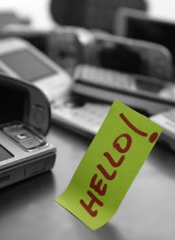 Assorted mobile phones and written word: HELLO. Message at the office