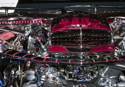 Detail from a modified car engine encased in shiny chrome and stainless steel