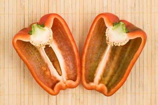 Cut red bell pepper, over bamboo mat, close up.