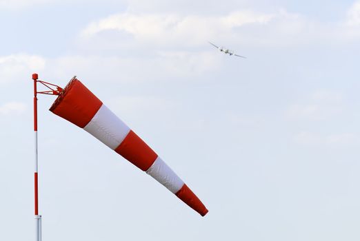 a windsock with a plane in the background