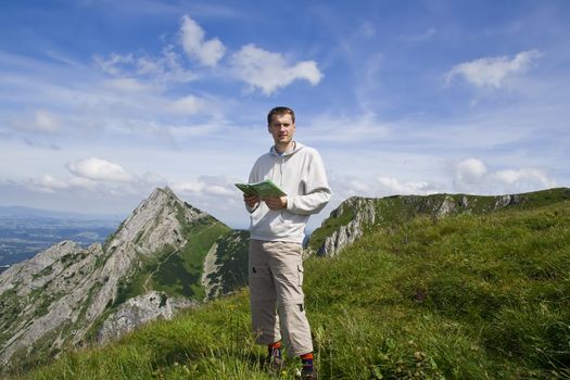 Mountain tourist with map over blue sky and mountains