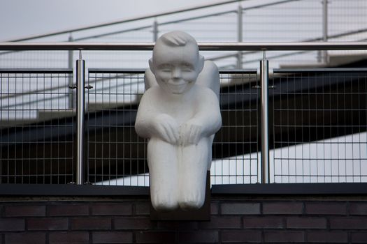 The white angel sits on the brink of a building roof