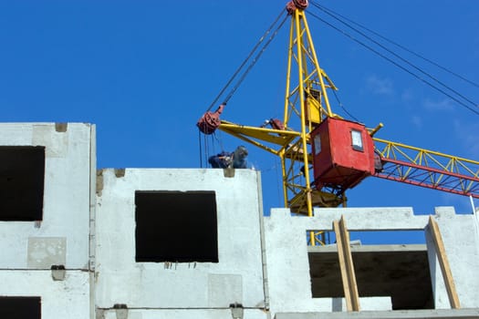 The welder on building of the house from ferro-concrete panels