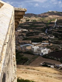 Majestic medieval walls overlooking the modern city outside the walls in Gozo citadel