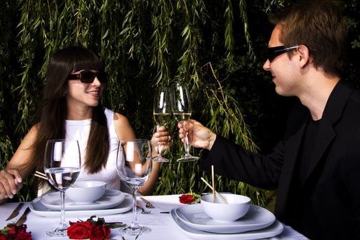 Couple having a romantic lunch in the garden enjoying wine