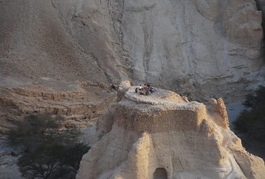 Group of young men on ruins of an ancient fortress in mountains