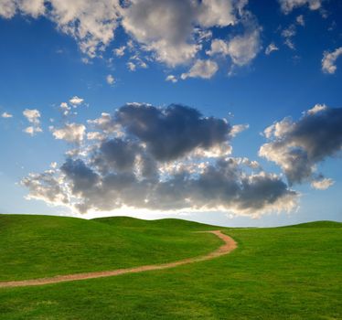 pedestrian path between green hills on a background picturesque sky