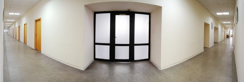 Panoramic shot of the office building corridor. Closed glass door