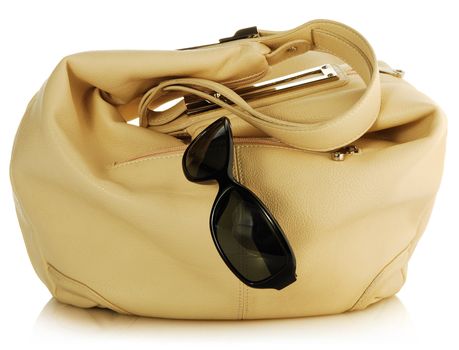 female light handbag and antisun glasses on white