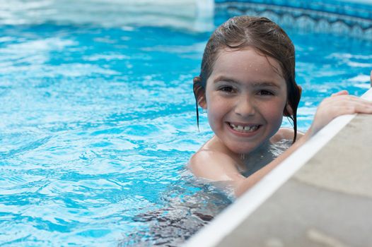a boy smiling in swimming pool