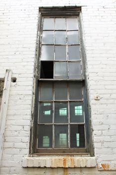 old broken window on worn brick wall