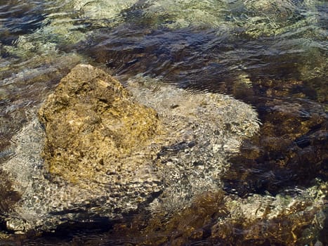 Abstract image of seawater surrounding a small rock