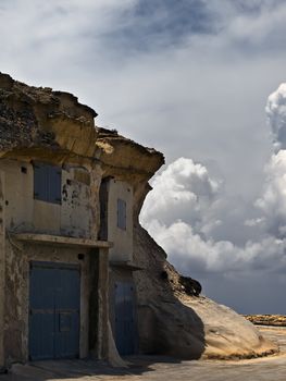 Cave dwellings or boathouse carved into soft sandstone in Qbajjar in Gozo