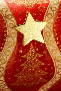 Christmas golden decoration with gold star over red background