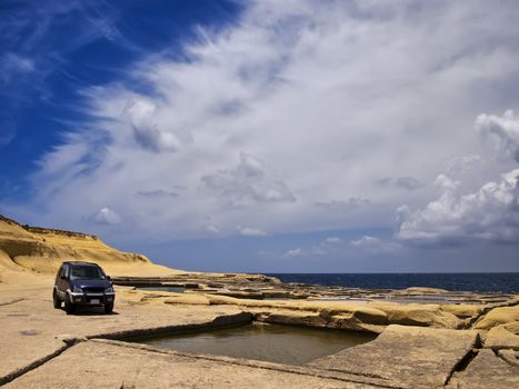 Offroad SUV on sandstone plains in Qbajjar in Gozo