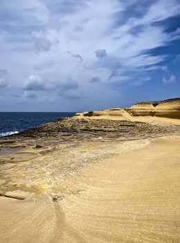 Ancient saltpanes from Roman times carved in sandstone in Qbajjar in Gozo